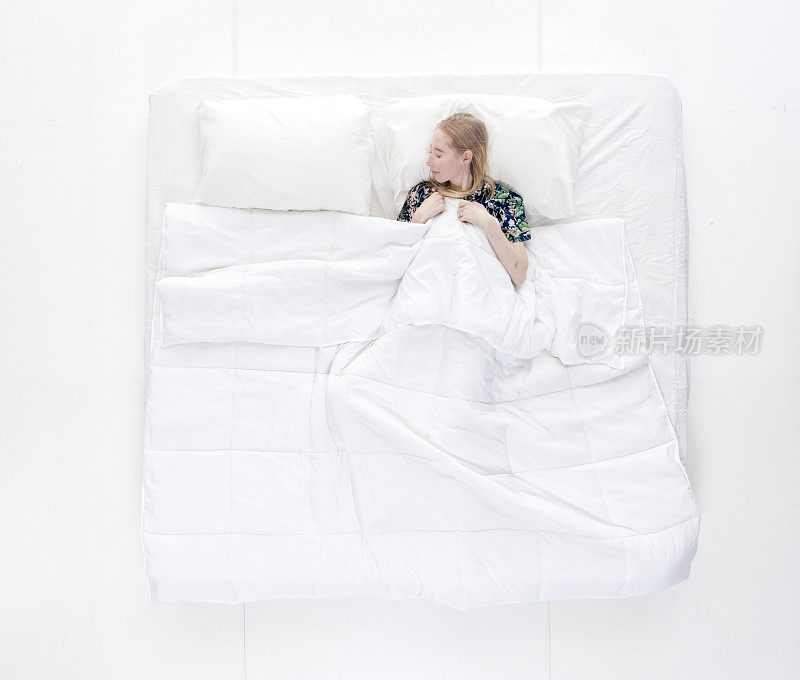 上图/全身/一个20-29岁的成年美丽的白人女性/年轻女性躺下/午睡/睡觉/放松/休息在卧室的白色背景穿着睡衣/诱惑/性感